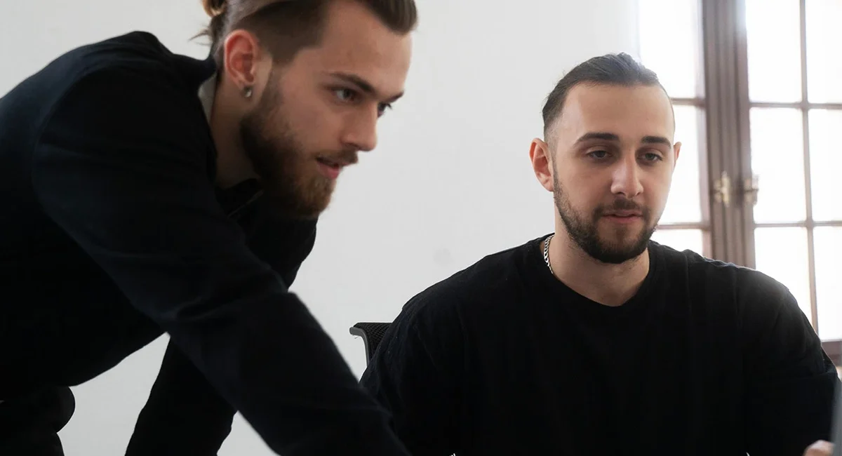 a group of men looking at a computer screen