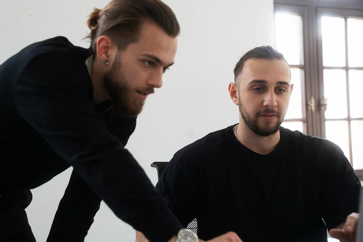 a group of men looking at a computer screen